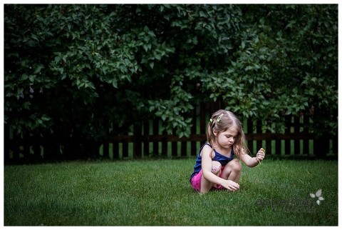 Color lifestyle photography shot of young child picking dandelions