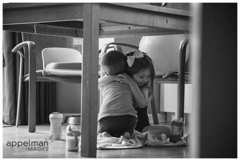 Naperville family photographer, naperville child photographer, lifestyle photographer, young children hugging, together, kids, indoor picnic, color portrait, photojournalistic, photojournalism, black and white picture