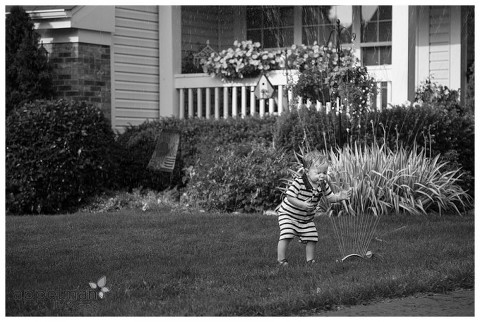 Naperville Child Photographer, Naperville Lifestyle Photographer, child portrait, kid portraits, child photo, kid photos, naperville photographer, oak park, IL, chicago, aurora IL, plainfield IL, family photographer, family portraits, sprinkler, black and white, toddlers, standing in the sprinkler