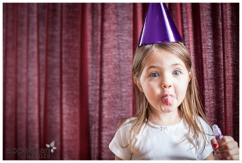 Photojournalistic Family Photography in Naperville with Party Hat, red curtain, red nails, purple party hat, young girl, quirky picture
