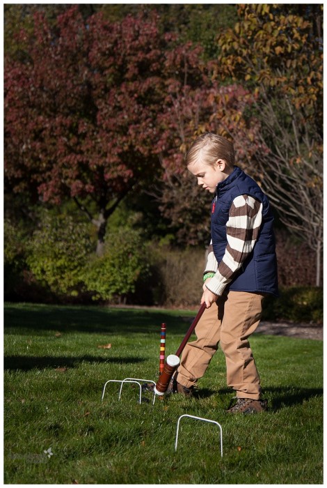 Boy playing croquet at home in Naperville for family lifestyle photography session
