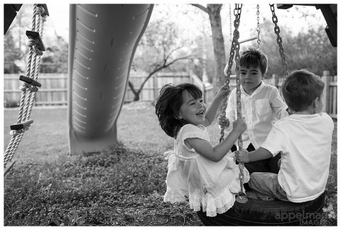 So much fun on a tire swing for little kids at home by Naperville Family Photographer