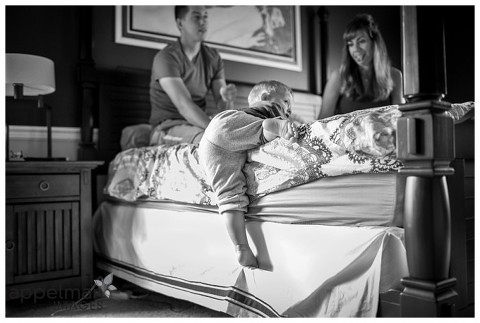 just a little bit higher baby toddler climbing on big bed to snuggle naperville lifestyle portrait photographer kate appelman black and white