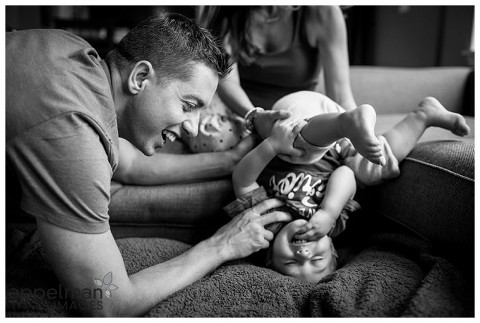 upside down baby with mom and dad on couch by photographer in naperville