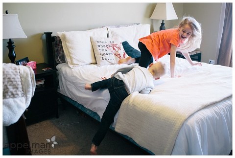 Kids climbing on bed for lifestyle portraits by naperville photographer