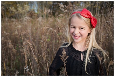 Beautiful girl with red bow in field session